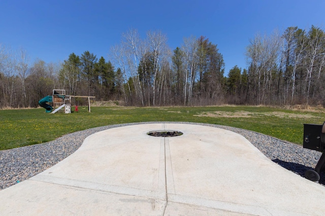 view of patio featuring a playground and an outdoor fire pit
