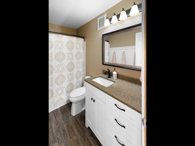 bathroom featuring wood finished floors, toilet, vanity, and a shower with curtain