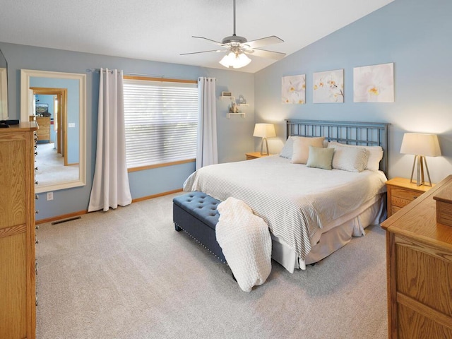 carpeted bedroom with baseboards, vaulted ceiling, and a ceiling fan