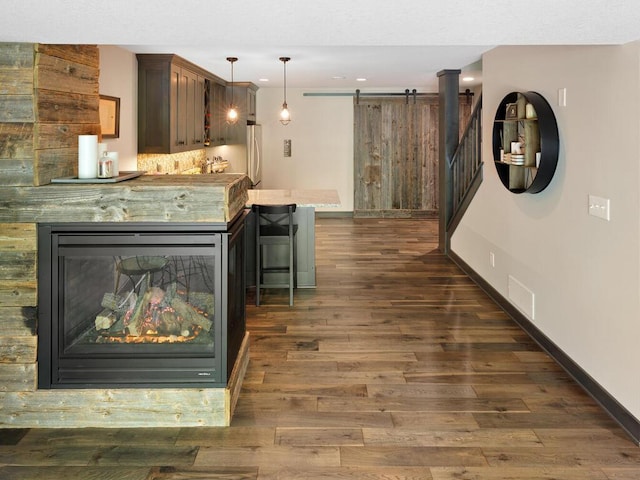kitchen featuring freestanding refrigerator, dark wood-style flooring, recessed lighting, a kitchen bar, and decorative light fixtures