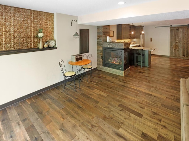 living room with dark wood-type flooring, baseboards, recessed lighting, and a multi sided fireplace