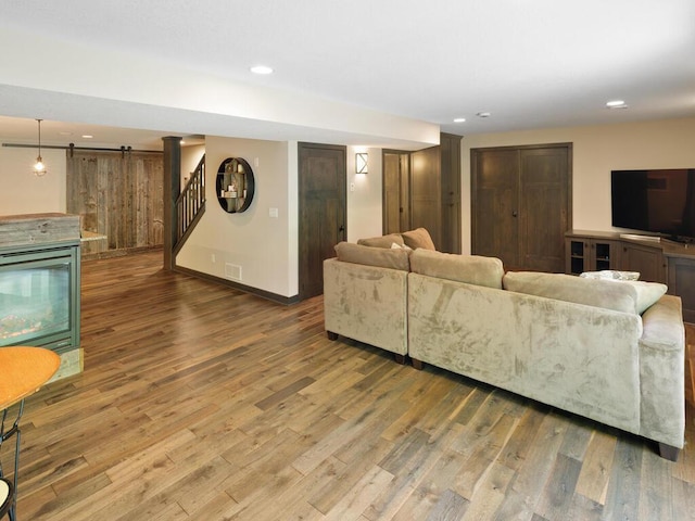 living room with wood finished floors, recessed lighting, stairs, and baseboards