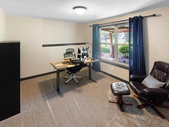 carpeted home office with baseboards and a textured ceiling