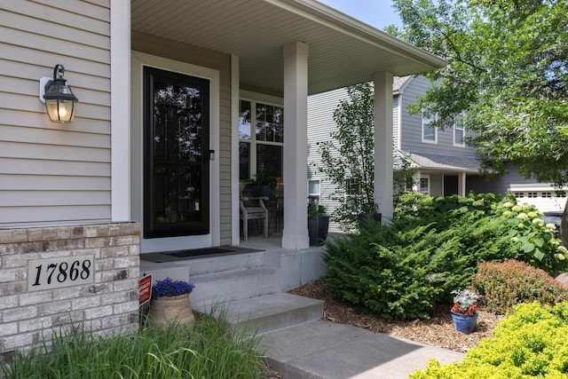doorway to property with a porch and stone siding