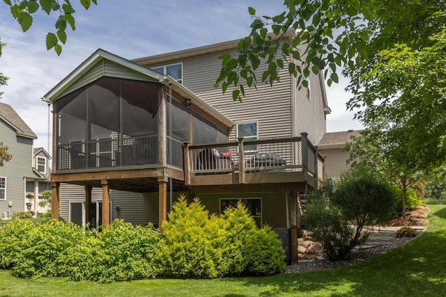 back of property featuring a sunroom, a yard, and a wooden deck