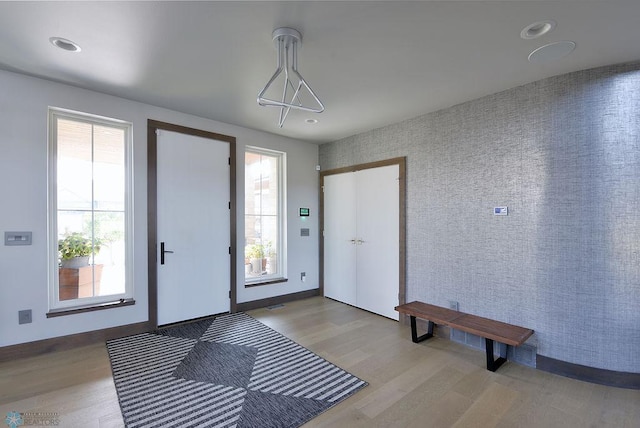 entryway featuring baseboards, a wealth of natural light, light wood-style flooring, and recessed lighting