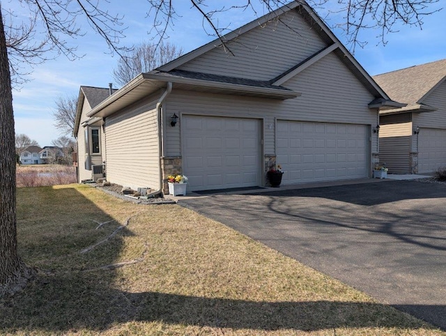 view of property exterior featuring driveway, a yard, a shingled roof, and a garage