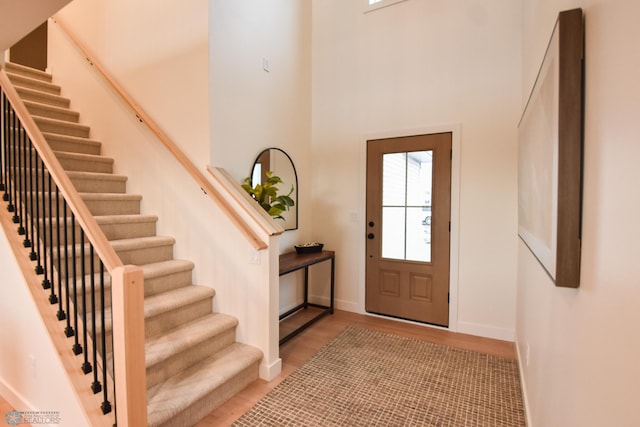 foyer featuring stairs, baseboards, plenty of natural light, and wood finished floors