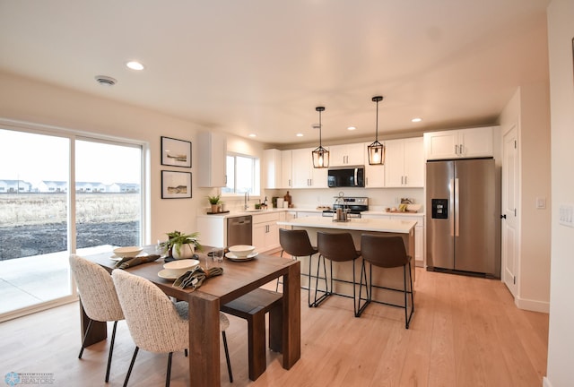 dining space featuring light wood-type flooring and recessed lighting