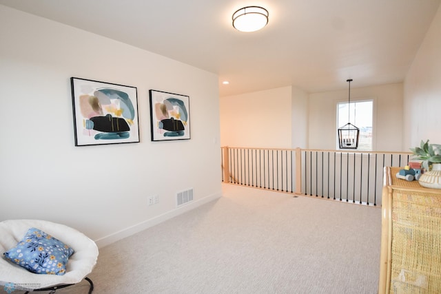 living area featuring visible vents, carpet, and baseboards