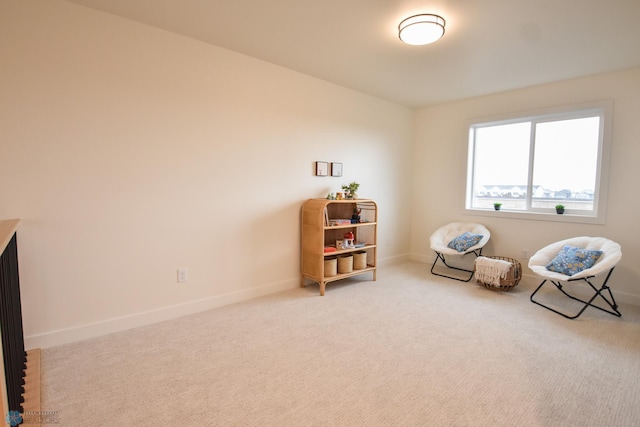 sitting room with baseboards and carpet floors