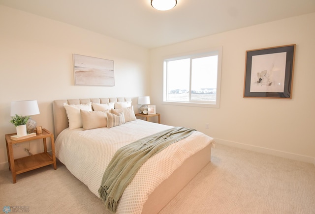 bedroom with baseboards and light colored carpet