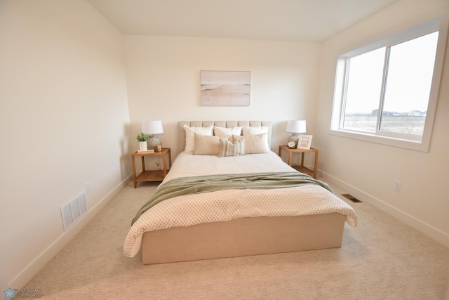 bedroom featuring baseboards, visible vents, and light carpet
