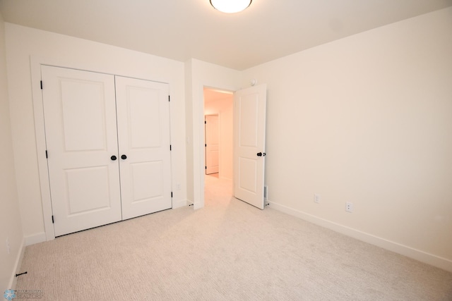 unfurnished bedroom featuring baseboards and light colored carpet