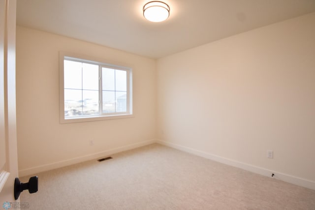 carpeted spare room with baseboards and visible vents