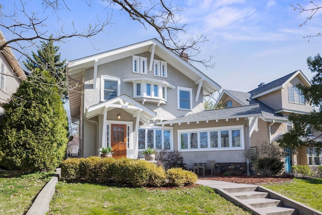 view of front of home featuring stucco siding and a front lawn