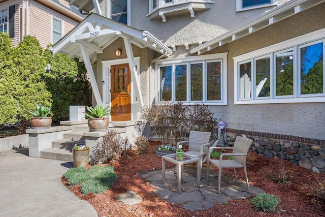 property entrance with a patio and stucco siding
