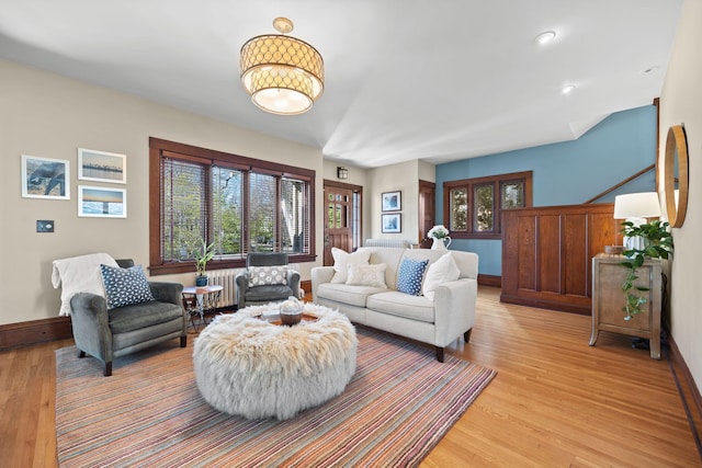 living room featuring baseboards, light wood finished floors, and radiator