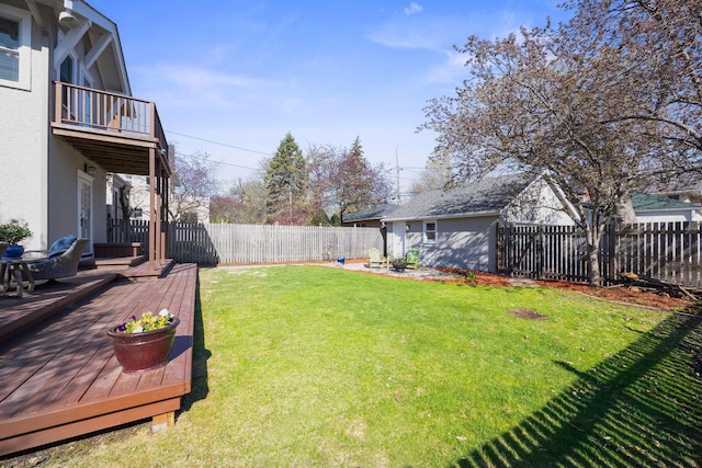 view of yard featuring a wooden deck, a fenced backyard, and a balcony