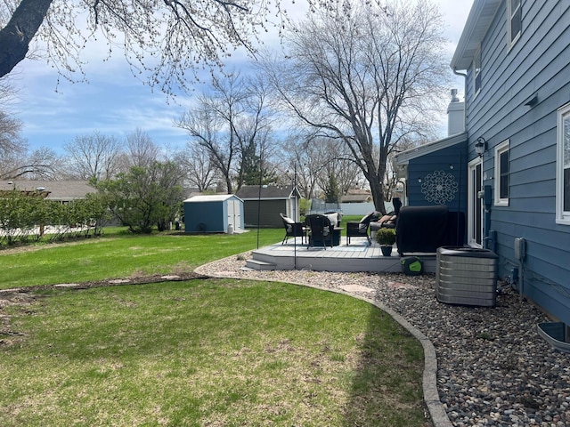 view of yard featuring a storage shed, an outbuilding, a patio area, and central AC