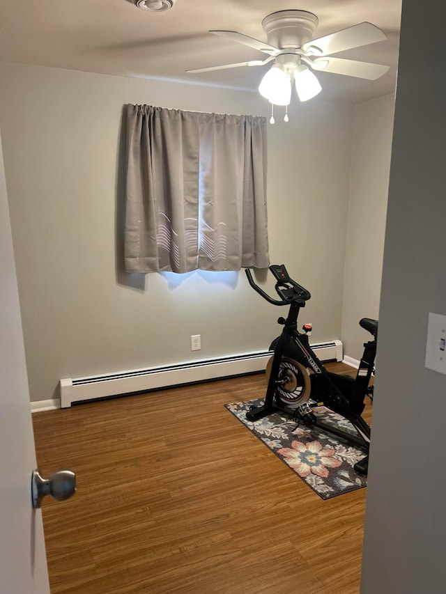 exercise area with ceiling fan, wood finished floors, and a baseboard radiator
