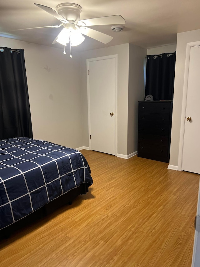 bedroom featuring baseboards, ceiling fan, and light wood-type flooring