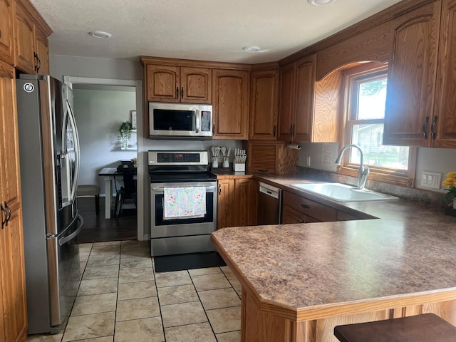 321 Meredith Rd, Albert Lea, MN 56007 - kitchen with appliances with stainless steel finishes, a sink, a peninsula, and brown cabinets