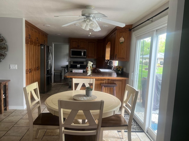 321 Meredith Rd, Albert Lea, MN 56007 - kitchen featuring stainless steel appliances, a sink, a ceiling fan, a peninsula, and light tile patterned floors