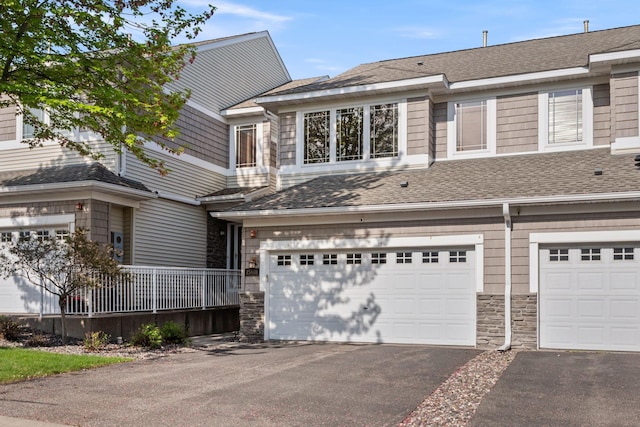15601 Lilac Dr, Eden Prairie, MN 55347 - townhome / multi-family property featuring driveway, a garage, stone siding, and a shingled roof