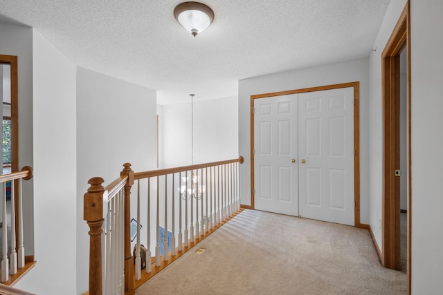 15601 Lilac Dr, Eden Prairie, MN 55347 - hallway with carpet floors, a textured ceiling, baseboards, an upstairs landing, and a chandelier