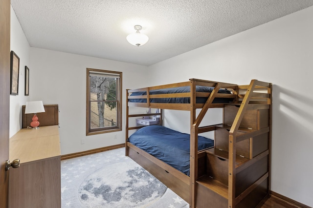 carpeted bedroom with a textured ceiling and baseboards