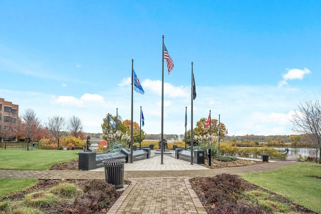 surrounding community featuring a lawn and a water view