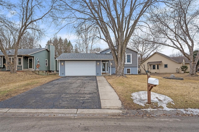 tri-level home with driveway, a front yard, and a garage