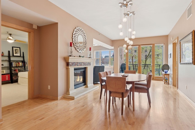 401 2nd St Unit 202, Minneapolis, MN 55401 - dining space with a glass covered fireplace, visible vents, baseboards, and light wood-style floors
