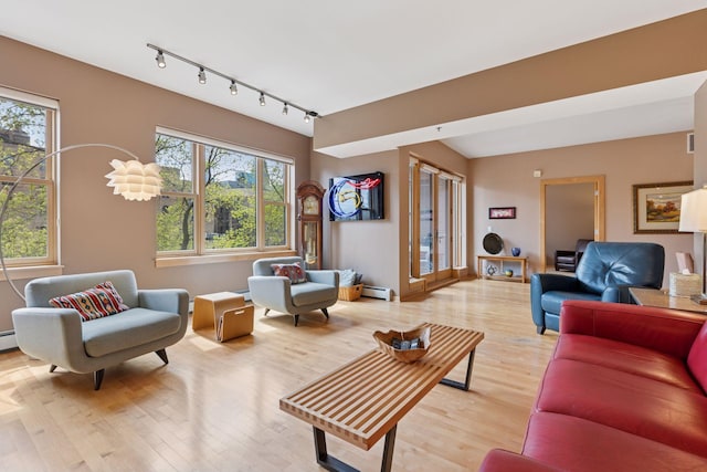 401 2nd St Unit 202, Minneapolis, MN 55401 - living area with track lighting, baseboard heating, light wood-style flooring, and a baseboard heating unit