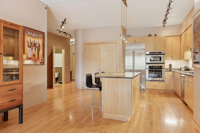 401 2nd St Unit 202, Minneapolis, MN 55401 - kitchen featuring light wood-style flooring, stainless steel appliances, a kitchen island, light brown cabinetry, and rail lighting