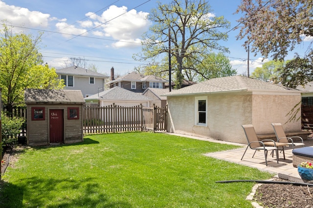 view of yard with an outdoor structure, a storage shed, and a patio area