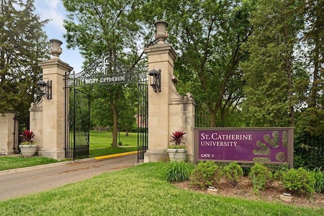 community sign with a gate and a yard