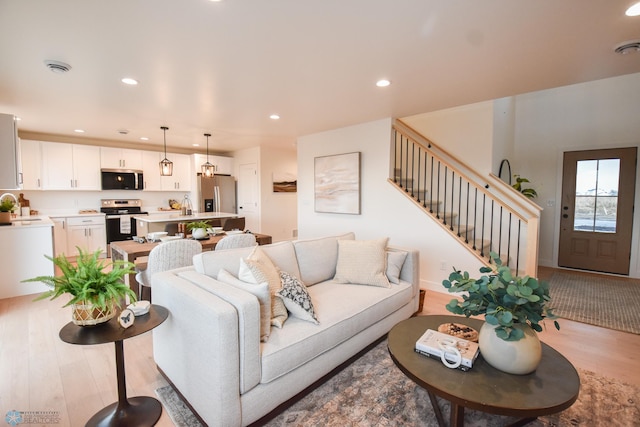 living area featuring stairway, recessed lighting, and wood finished floors