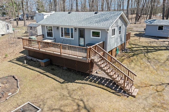 back of property featuring stairs, roof with shingles, and a wooden deck