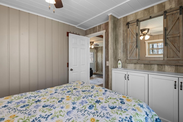 bedroom with ornamental molding and a barn door