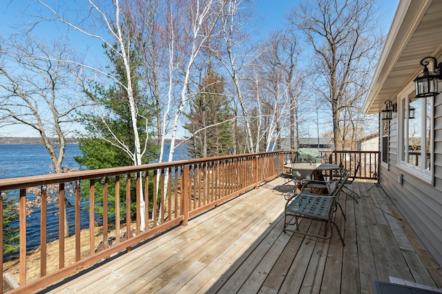 wooden deck with outdoor dining space and a water view