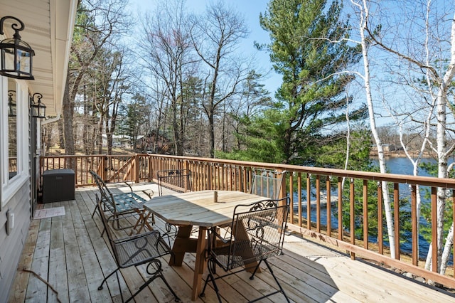 wooden deck with outdoor dining area and a water view