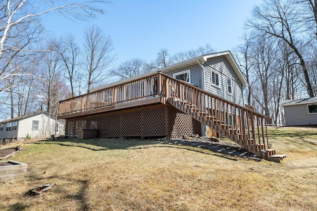 rear view of house with stairs, a yard, and a deck