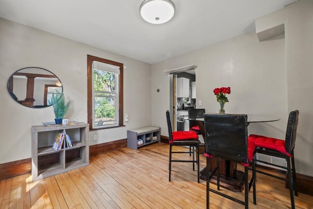 dining room featuring light wood-type flooring and baseboards