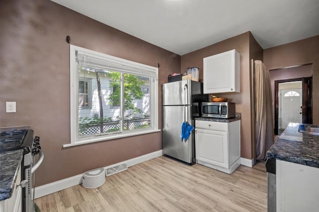 kitchen featuring appliances with stainless steel finishes, light wood-style flooring, white cabinetry, and baseboards