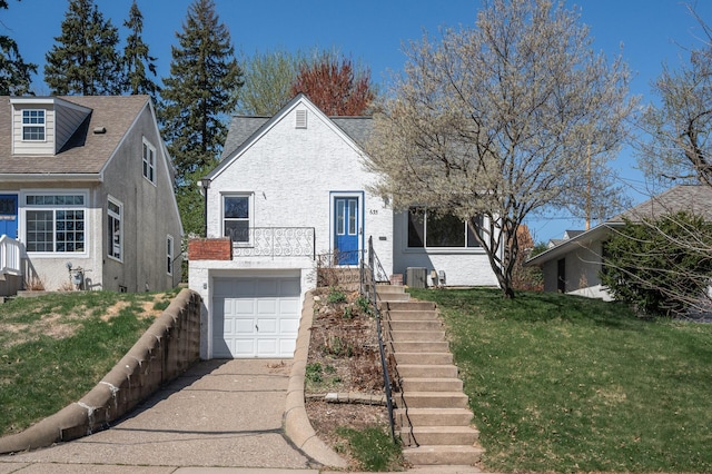 bungalow-style house with brick siding, a garage, a front lawn, and driveway