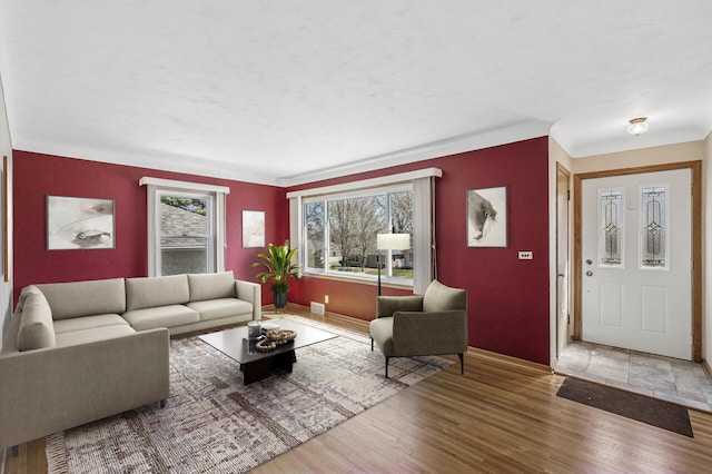 living area with baseboards, wood finished floors, and visible vents