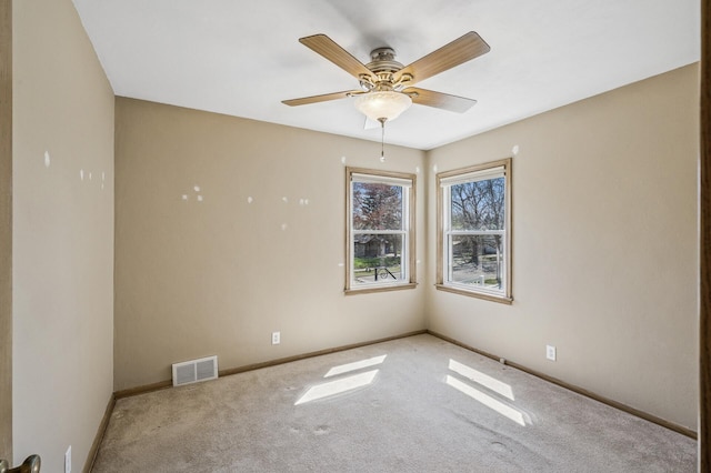 empty room featuring baseboards, ceiling fan, carpet, and visible vents