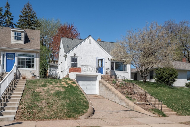 bungalow featuring a garage, a front lawn, a chimney, brick siding, and stairway